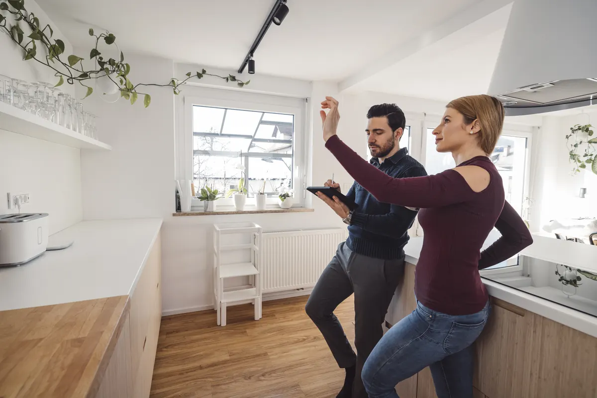 Couple touring a bright kitchen and talking through their plans