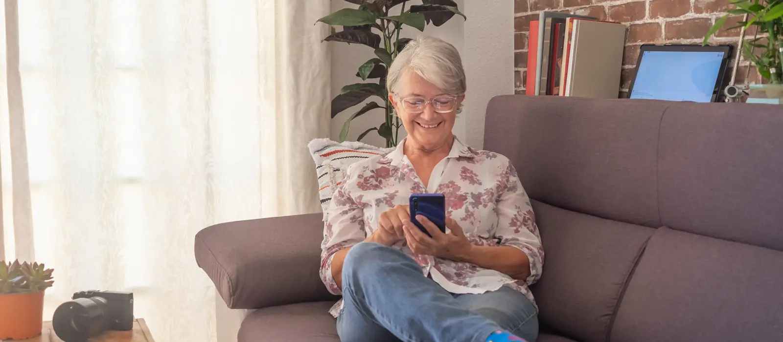 Smiling homeowner on her sofa checking her phone