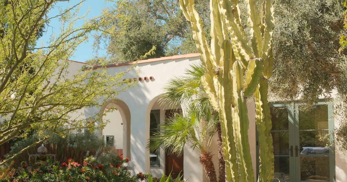 Single-story Spanish-style home with arched entry and garden