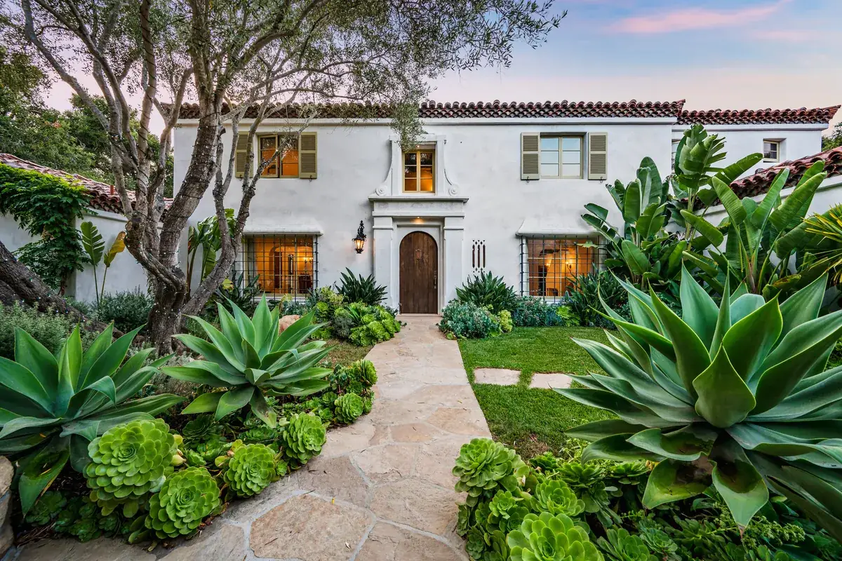 Spanish-style California home with a stone path and drought-tolerant garden