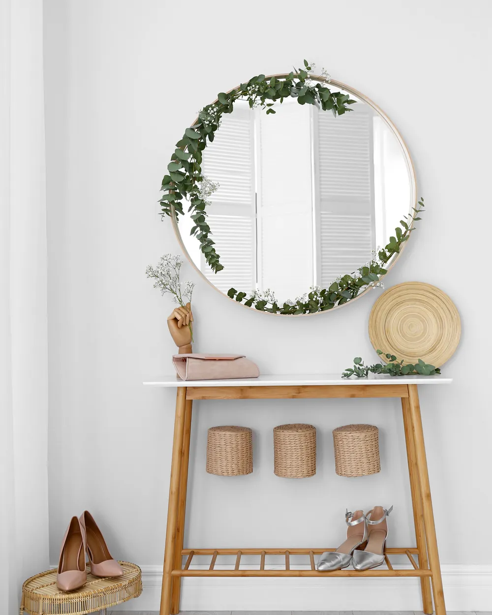 Simple styled entryway with a round mirror, wood console table and baskets