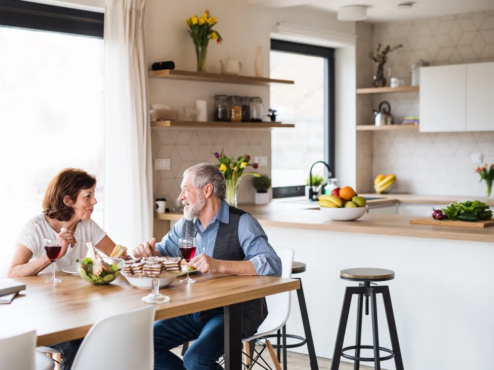 Older couple talking over a meal at their kitchen table