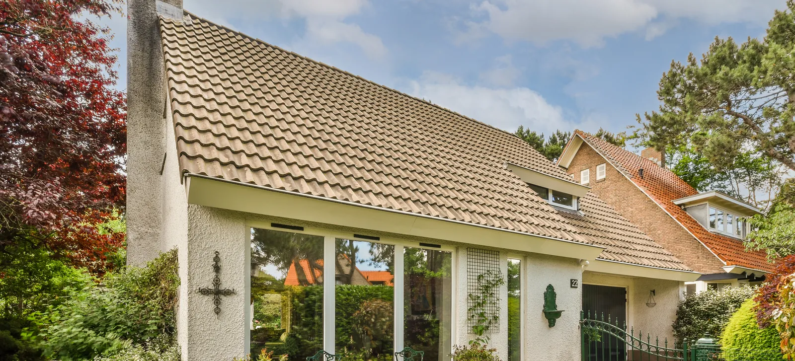 Single family home with a tile roof and a lush garden